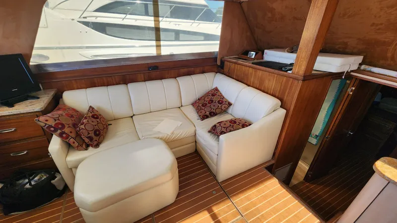 Slide: The Image of 1969 Hatteras 36 Sport Fisherman interior with white sofa and wooden accents. - 24