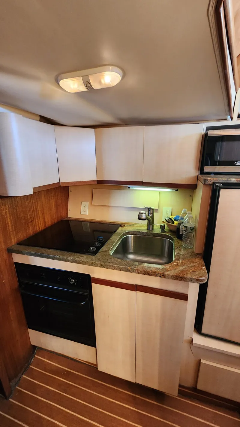 Slide: The Image of 1969 Hatteras 36 Sport Fisherman yacht kitchen with modern appliances and wood accents. - 26