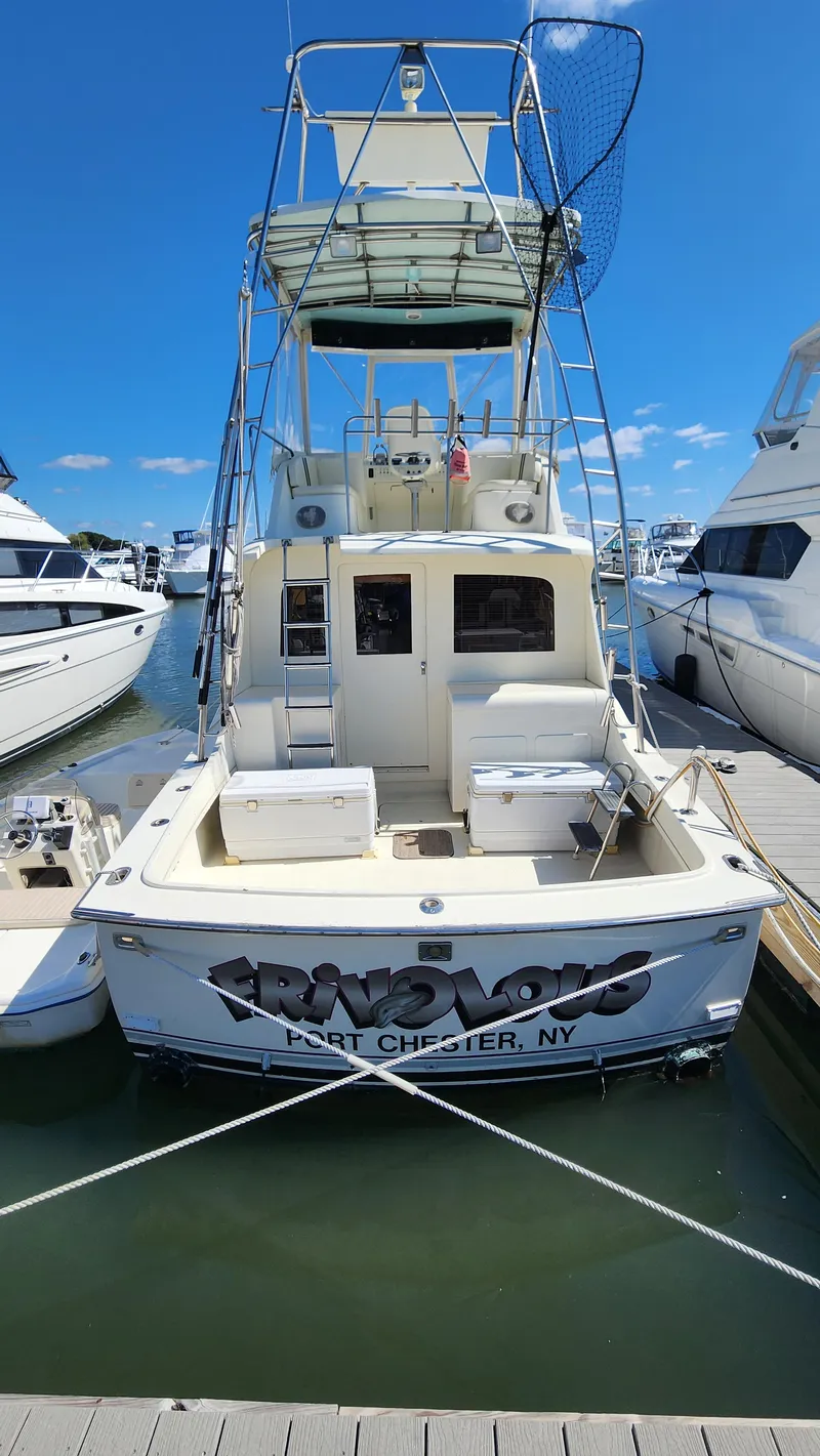 Slide: The Image of 1969 Hatteras 36 Sport Fisherman docked, featuring a spacious deck and flybridge. - 3