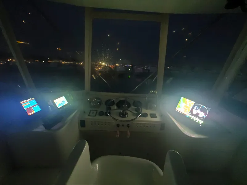 Slide: The Image of Helm of 1969 Hatteras 36 Sport Fisherman at night with illuminated navigation screens. - 37