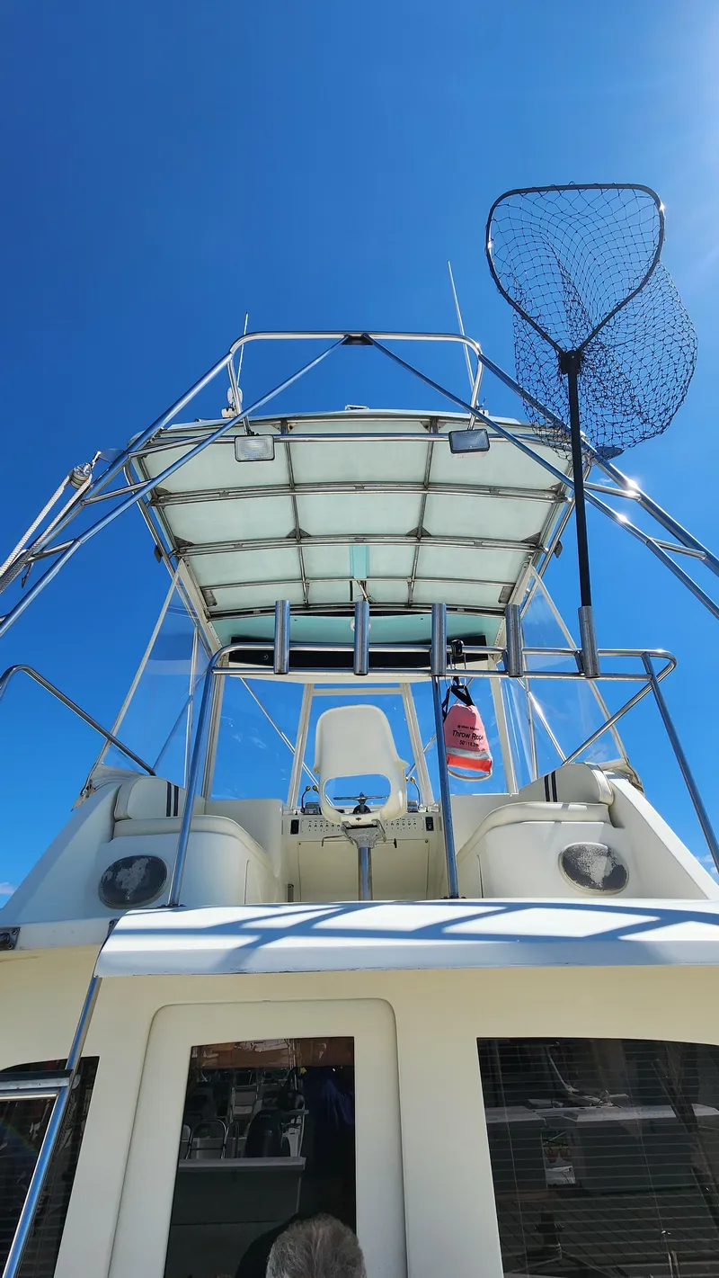 Slide: The Image of 1969 Hatteras 36 Sport Fisherman boat with fishing net, clear sky background. - 4
