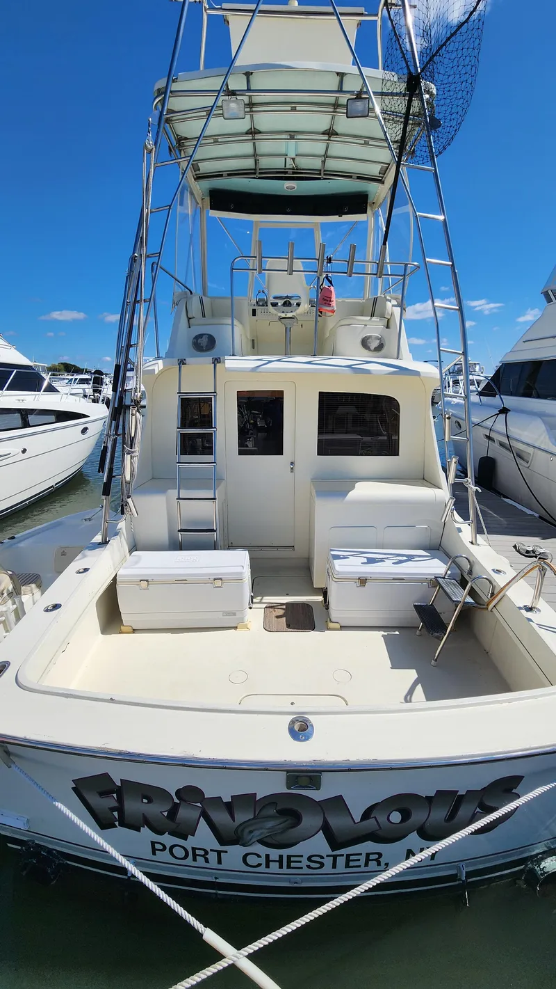 Slide: The Image of 1969 Hatteras 36 Sport Fisherman boat docked, featuring spacious deck and tower. - 5