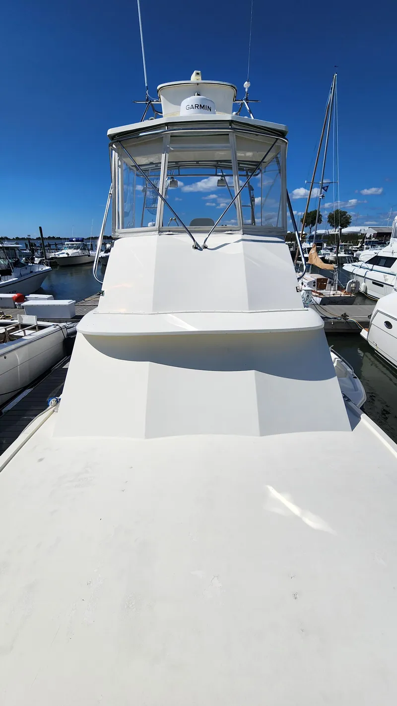 Slide: The Image of 1969 Hatteras 36 Sport Fisherman boat docked at marina under clear blue sky. - 6