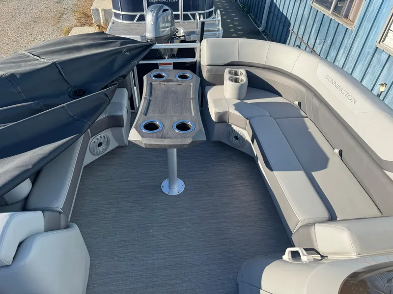 Slide: The Image of 2023 Bennington 23SX Swingback pontoon boat interior with gray seating and table. - 11