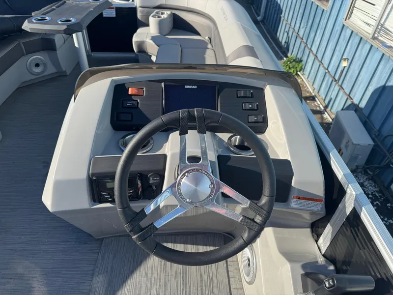 Slide: The Image of 2023 Bennington 23SX Swingback boat dashboard with steering wheel and controls. - 2