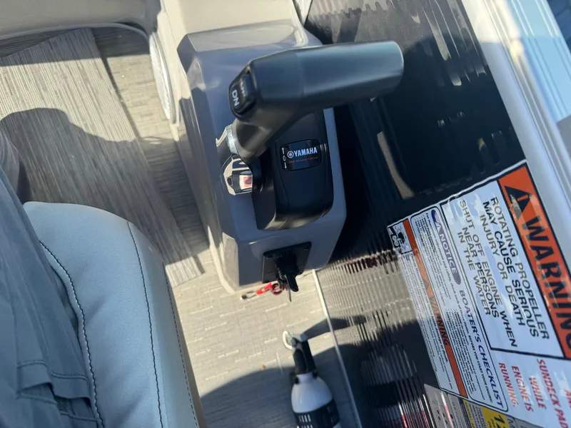 Slide: The Image of Close-up of 2023 Bennington 23SX Swingback boat controls and warning labels. - 5