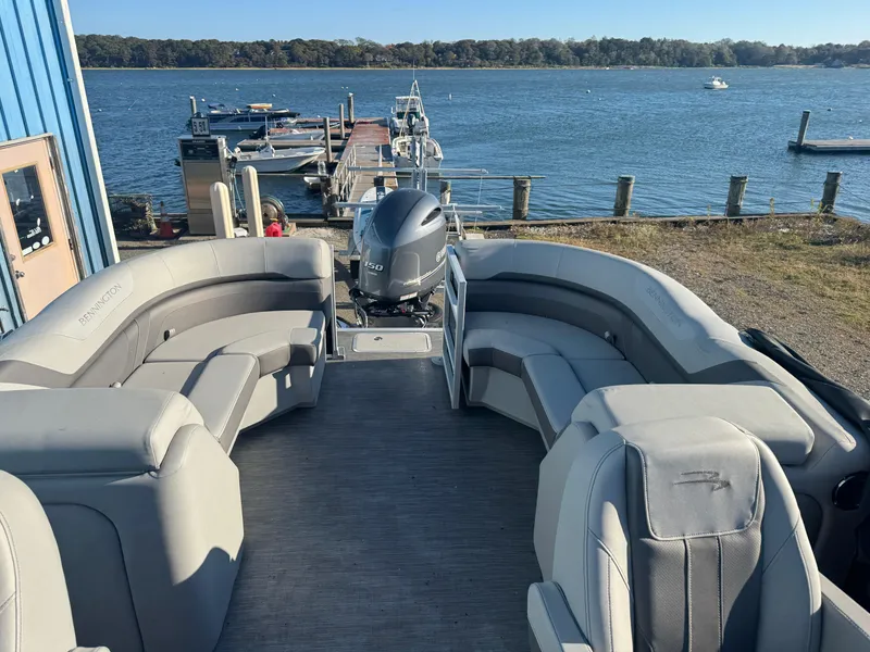 Slide: The Image of 2023 Bennington 23SX Swingback pontoon boat docked by a scenic lake. - 8