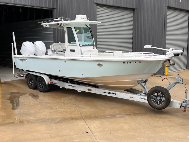 Slide: The Image of 2018 Everglades 273 Center Console boat on trailer, parked outside a warehouse. - 0