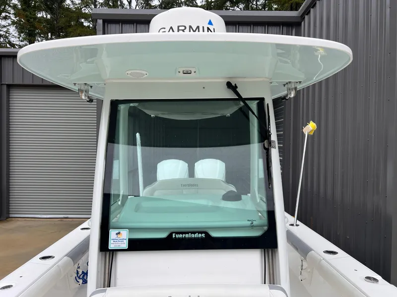 Slide: The Image of 2018 Everglades 273CC boat with Garmin equipment, docked near a metal building. - 16