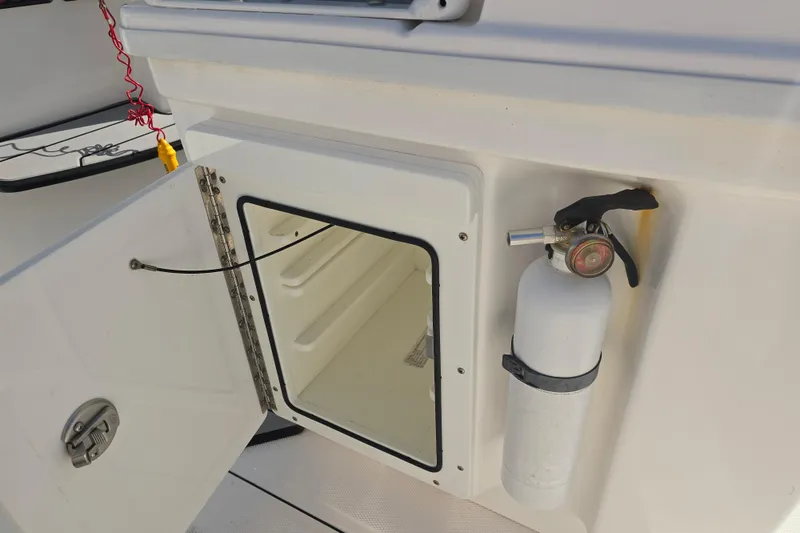 Slide: The Image of Open storage compartment and fire extinguisher on 2018 Everglades 273 Center Console boat. - 41