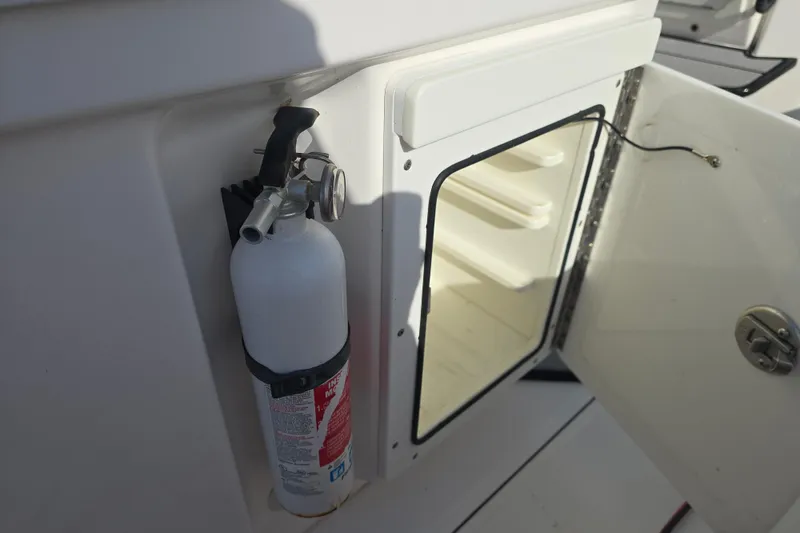 Slide: The Image of 2018 Everglades 273 Center Console boat with open storage compartment and mounted fire extinguisher. - 43