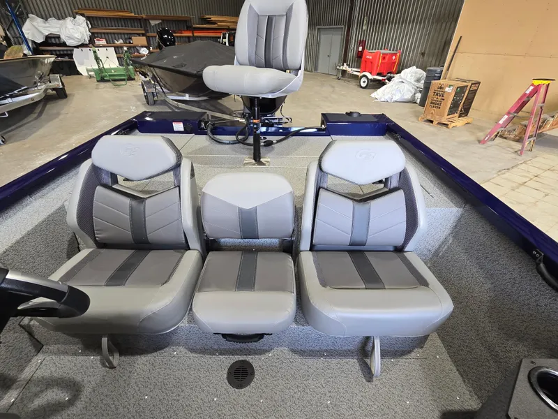 Slide: The Image of 2025 G3 Sportsman 1710 boat interior with three gray seats in a workshop setting. - 11