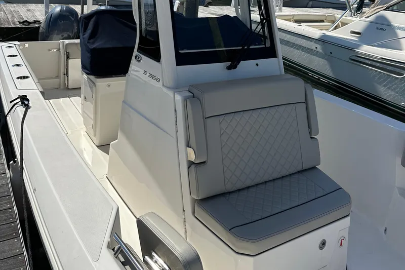 Slide: The Image of 2024 Pursuit S 268 Sport boat with cushioned seating and sleek design. - 14