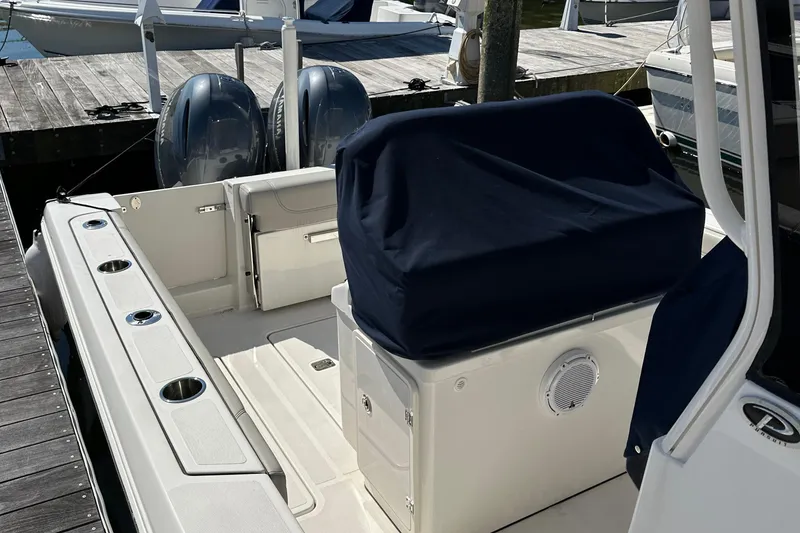 Slide: The Image of 2024 Pursuit S 268 Sport boat with covered seating and dual engines at dock. - 15