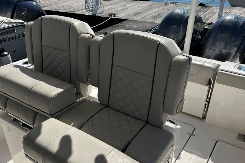 Slide: The Image of 2024 Pursuit S 268 Sport boat seats with quilted design and dual engines in background. - 21