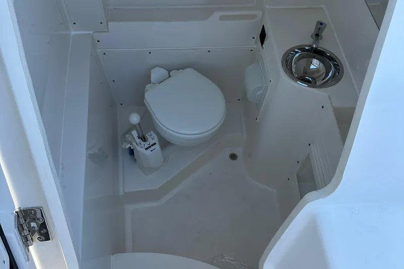 Slide: The Image of 2024 Pursuit S 268 Sport boat interior bathroom with toilet and sink. - 22