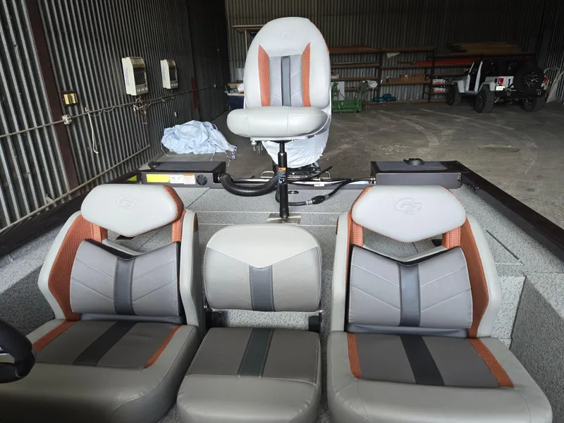 Slide: The Image of 2025 G3 Sportsman 1810 PFX boat interior with three gray and orange seats. - 14