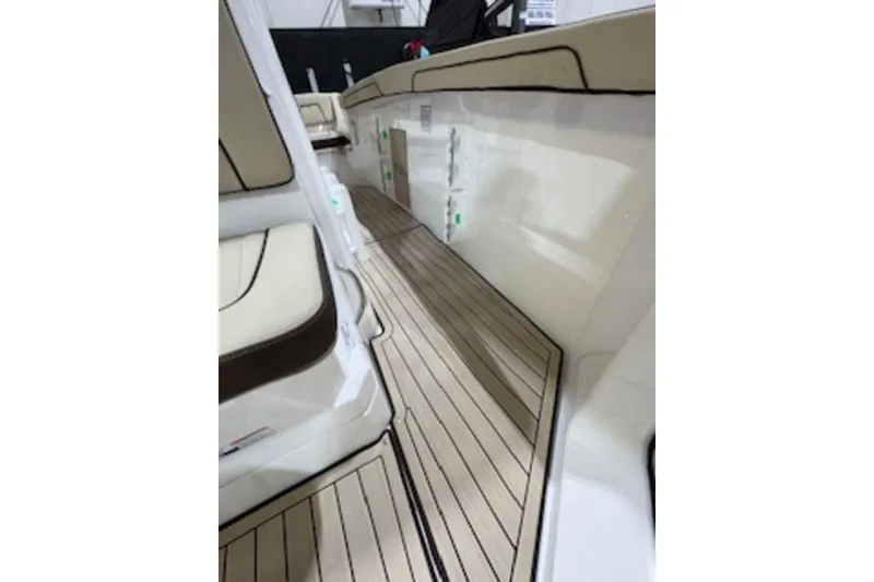 Slide: The Image of 2025 Yamaha Boats 252 FSH Sport interior with sleek seating and wood-style flooring. - 16