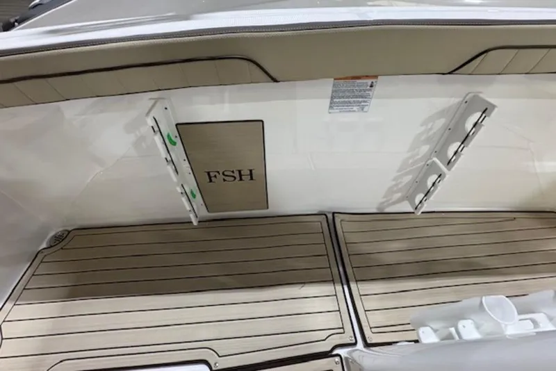 Slide: The Image of 2025 Yamaha Boats 252 FSH Sport interior with wood finish and rod holders. - 17