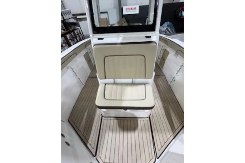 Slide: The Image of 2025 Yamaha Boats 252 FSH Sport interior with beige seating and wood-style flooring. - 7