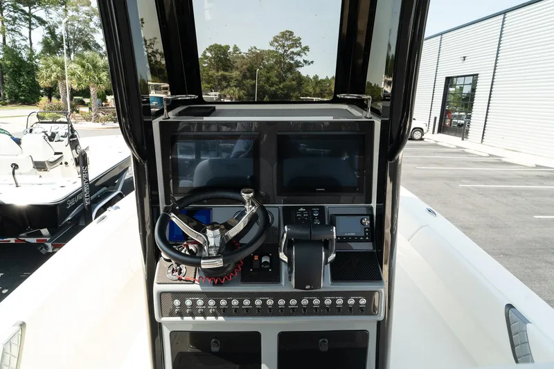 Slide: The Image of ShearWater 27 Carolina Open 2025 boat console with dual screens and controls. - 17