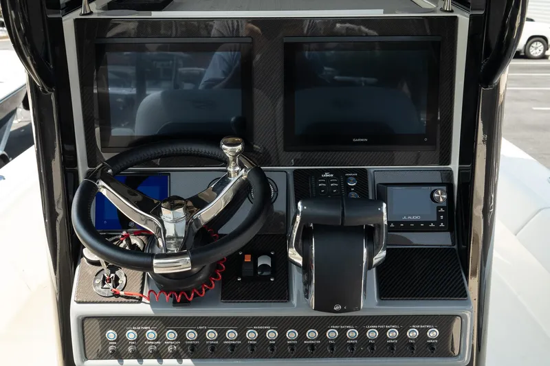 Slide: The Image of 2025 ShearWater 27 Carolina Open boat dashboard with dual screens and steering wheel. - 18