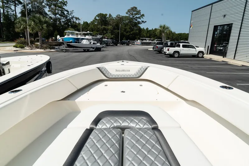 Slide: The Image of 2025 ShearWater 27 Carolina Open boat, bow view in a marina setting. - 27