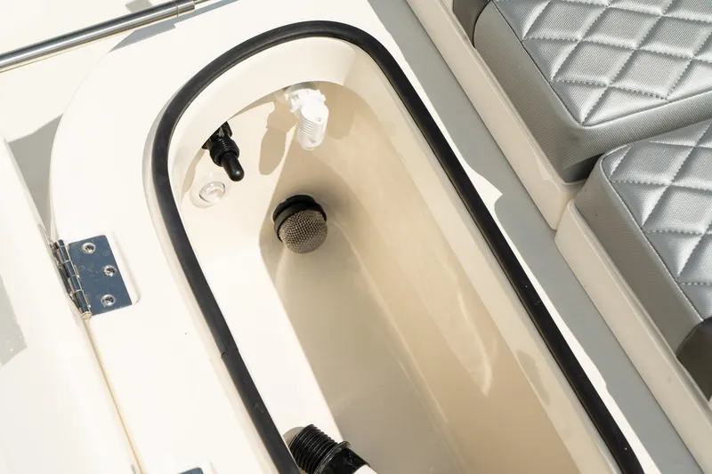 Slide: The Image of 2025 ShearWater 27 Carolina Open boat interior with storage compartment and cushioned seating. - 32
