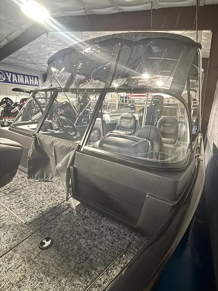 Slide: The Image of 2025 Tracker PG V175 CB boat interior with seating and canopy in showroom. - 12