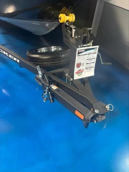 Slide: The Image of 2025 Tracker PG V175 CB trailer hitch with spare tire on blue floor. - 9