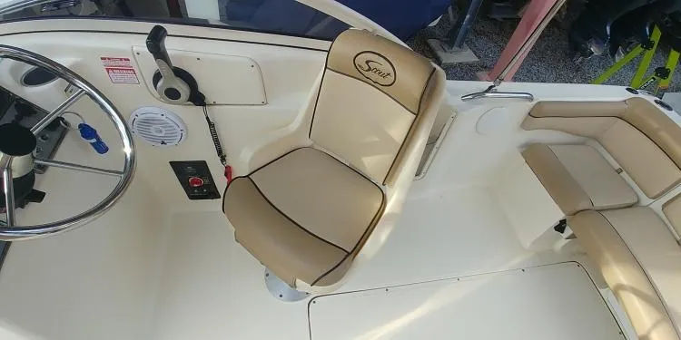 Slide: The Image of 2013 Scout 210 Dorado boat interior with steering wheel and beige seating. - 17