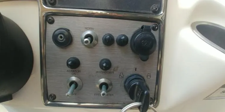Slide: The Image of Control panel of a 2013 Scout 210 Dorado boat with switches and ignition key. - 22