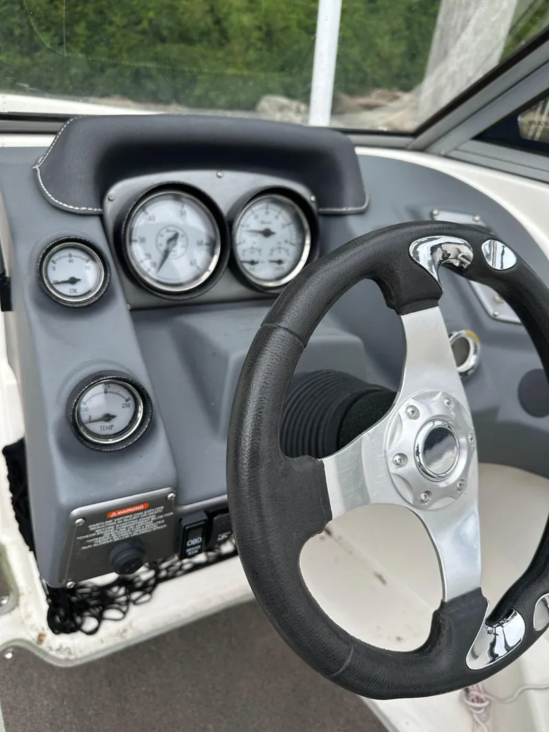 Slide: The Image of 2012 Chaparral 220 SSi boat dashboard with steering wheel and gauges. - 9