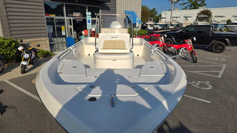 Slide: The Image of 2025 Bulls Bay 2000 boat displayed outdoors near motorcycles and a building. - 6