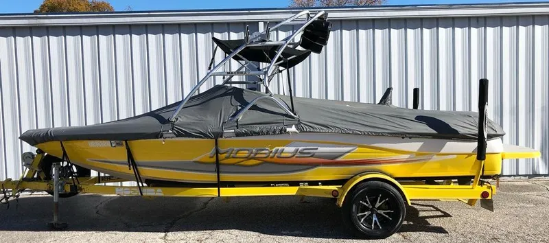 Slide: The Image of 2002 Moomba Mobius LSV boat, yellow with cover, parked on trailer. - 20
