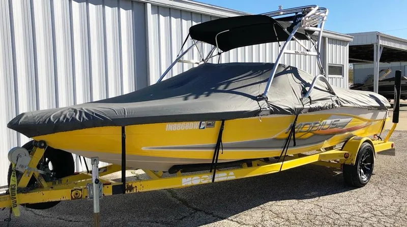 Slide: The Image of 2002 Moomba Mobius LSV boat, yellow with cover, parked on trailer. - 9