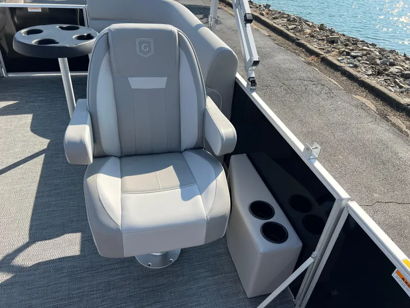Slide: The Image of 2025 Godfrey Xperience 2286 SBX boat seat with cup holders by the water. - 11