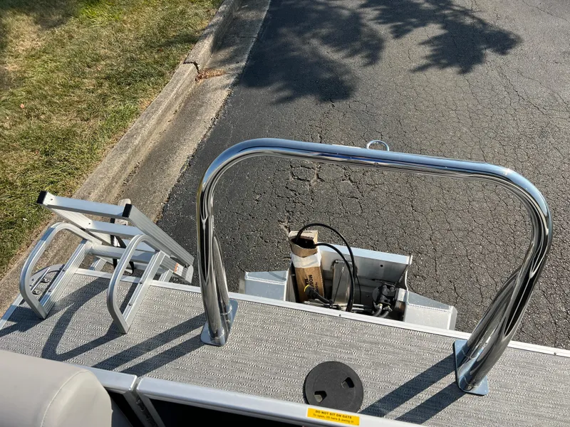 Slide: The Image of 2025 Godfrey Xperience 2286 SBX boat with chrome railing and ladder on asphalt. - 15