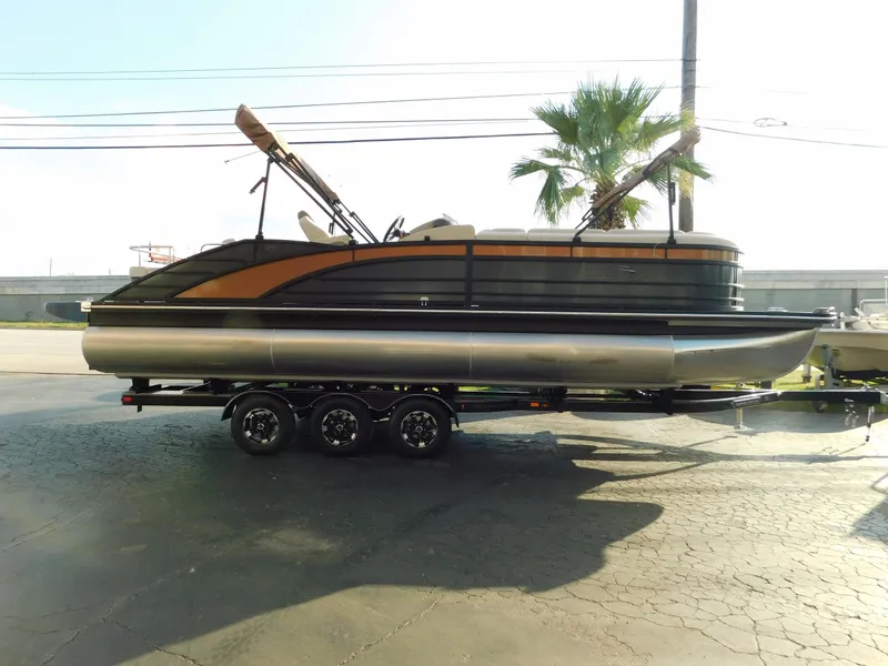 The Image of 2018 Bennington 25 R pontoon boat on a trailer, parked outdoors. - 0
