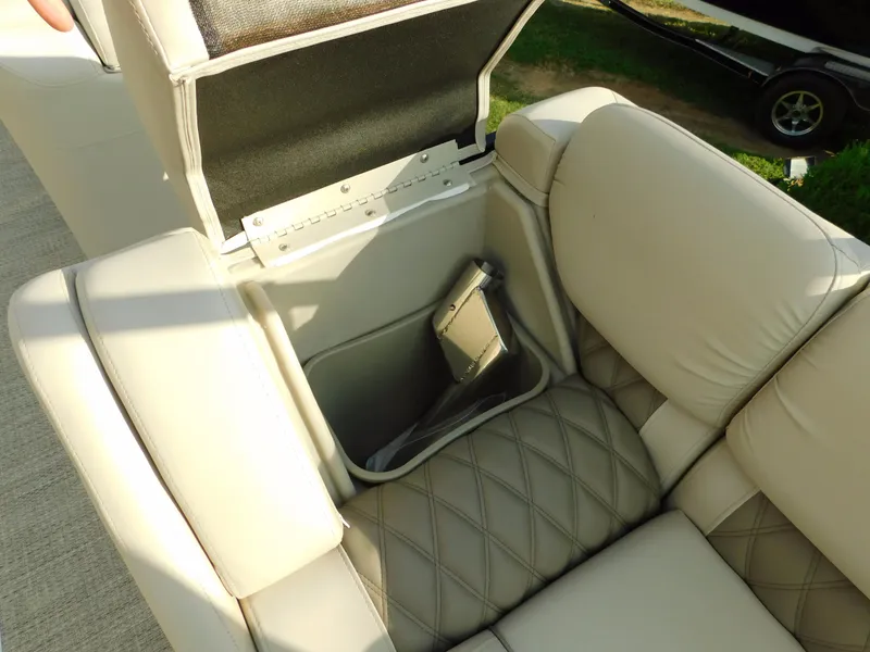 Slide: The Image of 2018 Bennington 25 R boat seat with storage compartment open, showcasing quilted upholstery. - 13