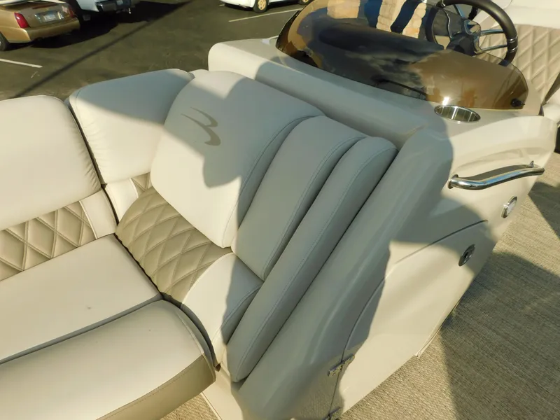Slide: The Image of 2018 Bennington 25 R boat interior with beige seating and steering console. - 16