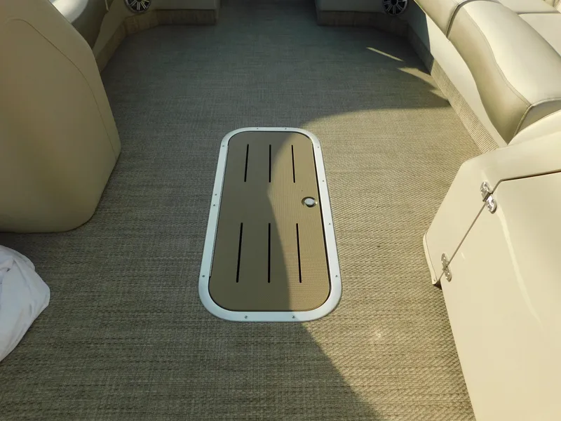 Slide: The Image of 2018 Bennington 25 R boat interior with beige seating and carpeted flooring. - 23