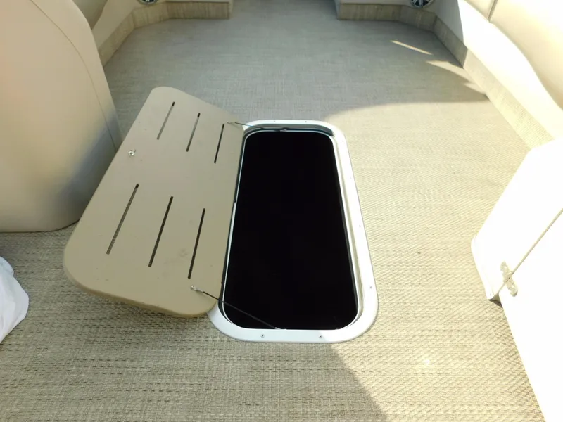 Slide: The Image of Open storage compartment on 2018 Bennington 25 R boat with beige interior. - 24