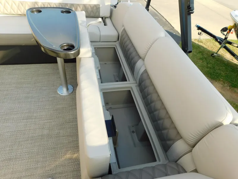 Slide: The Image of 2018 Bennington 25 R boat interior with beige seating and storage compartments. - 28