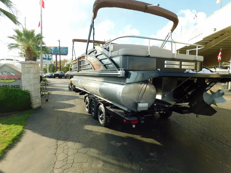 Slide: The Image of 2018 Bennington 25 R pontoon boat on a trailer, parked outdoors. - 6