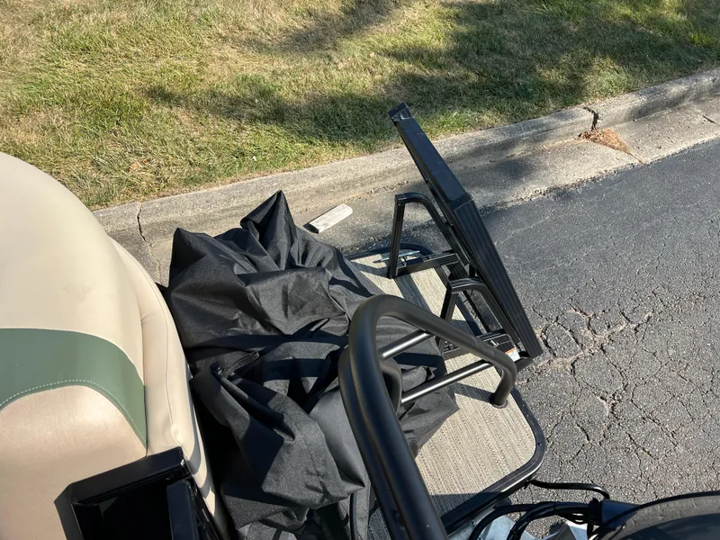 Slide: The Image of Golf cart with folded black canopy on a sunny street, near grass. - 16