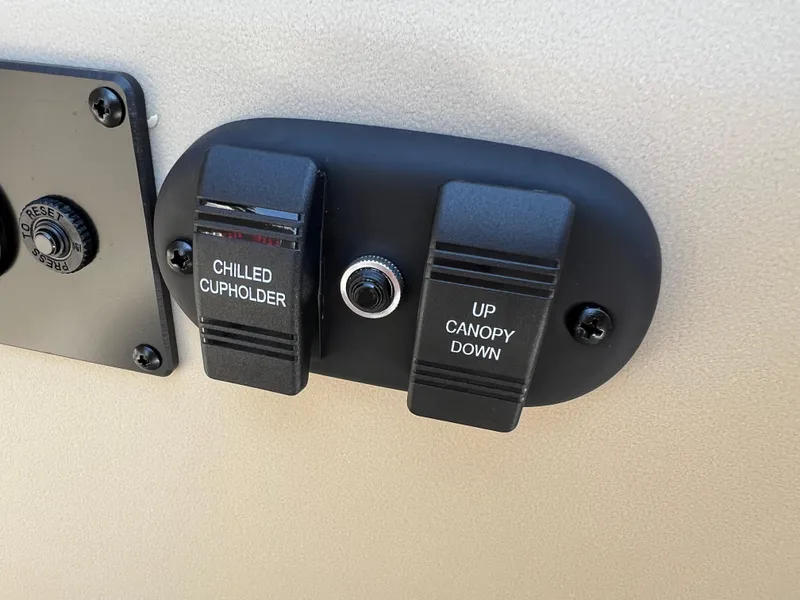 Slide: The Image of Control panel of 2025 Godfrey SWEETWATER 2286 MT with chilled cupholder and canopy switches. - 22