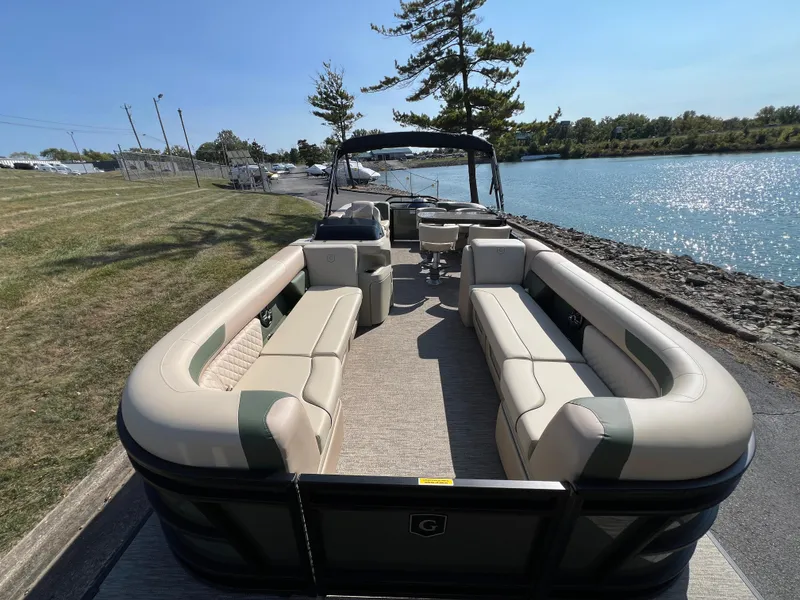 Slide: The Image of 2025 Godfrey SWEETWATER 2286 MT pontoon boat docked by a scenic lakeside. - 6