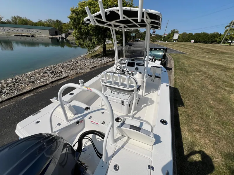 Slide: The Image of 2025 Robalo 206 Cayman boat with T-top, docked near a calm waterway. - 9