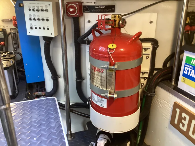 Slide: The Image of Engine room of 2020 Formula 380 Super Sport Crossover with fire extinguisher and control panel. - 16